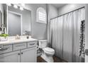 Cozy bathroom with wood floors, a white vanity, a toilet and a shower at 214 W Beverly Ln, Phoenix, AZ 85023