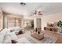 Staged living room with a white couch, neutral rug, ceiling fan, and view of the eat-in kitchen at 2893 E Cherry Hills Dr, Chandler, AZ 85249