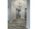 Inviting home foyer with a stylish ceiling light and wood look tile at 32978 N 131St Dr, Peoria, AZ 85383
