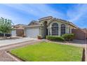Inviting single-story home with a well-manicured lawn, landscaping, and a two-car garage at 3418 W Maldonado Rd, Phoenix, AZ 85041