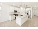 Bright kitchen featuring white cabinets, granite countertops, a kitchen island, and stainless steel appliances at 37069 W Prado St, Maricopa, AZ 85138