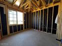 Unfinished bedroom showing exposed studs, black paper, and one window overlooking the property at 4345 E Brook Lynn Pl, San Tan Valley, AZ 85143