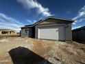 Newly built single-story home with an attached garage and gray exterior on a sunny day with a blue sky at 4345 E Brook Lynn Pl, San Tan Valley, AZ 85143
