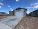 A single-story home featuring a gray stucco exterior, a two-car garage, and a long concrete driveway at 4345 E Brook Lynn Pl, San Tan Valley, AZ 85143