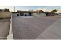 A single-story home has desert landscaping, brick driveway, and an attached garage at 5338 W Wolf St, Phoenix, AZ 85031