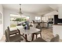 Bright kitchen with white cabinetry, tile floors, and a modern dining area with backyard views at 6873 E Kathleen Rd, Scottsdale, AZ 85254