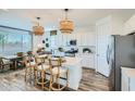 Open-concept kitchen and dining area featuring a large island with seating and stylish pendant lights above at 8331 E Petunia Ave, Mesa, AZ 85212