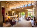 Bright living room featuring beamed ceilings, clerestory windows, a fireplace and sliding glass doors to the pool at 8502 E Cave Creek Rd # 61, Carefree, AZ 85377
