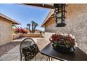 Charming front patio with seating area, lush bougainvillea, and desert landscaping at 9226 W Topeka Dr, Peoria, AZ 85382