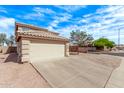 Angle view of a two-car garage with desert landscaping and a red tile roof in front of neighborhood street at 11501 N Pablo St, El Mirage, AZ 85335