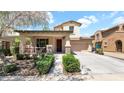 Charming two-story home featuring a covered porch, stone accents, and a well-manicured front yard at 13256 N 153Rd Dr, Surprise, AZ 85379