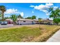 Expansive front yard featuring a single story home with a charming carport and vibrant turquoise doors at 1451 E Brown Rd, Mesa, AZ 85203
