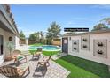 Backyard features a pristine pool, a pool house/teen room, and patio seating for lounging by the pool at 16008 N 60Th St, Scottsdale, AZ 85254