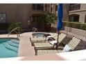 Poolside view with lounge chairs, blue umbrellas, and a clear blue pool, with palm trees and a jacuzzi at 16631 E El Lago Blvd # 212, Fountain Hills, AZ 85268