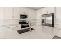 Bright kitchen featuring stainless steel appliances, white cabinets, quartz countertops, and subway tile backsplash at 18189 W Hess St, Goodyear, AZ 85338