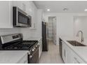 Open kitchen featuring stainless steel appliances, white cabinets, pantry and an island with a sink at 18189 W Hess St, Goodyear, AZ 85338