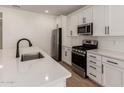 Bright kitchen featuring white cabinets, stainless steel appliances, and a subway tile backsplash at 18195 W Hess St, Goodyear, AZ 85338