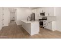 Open-concept kitchen featuring white cabinets, stainless steel appliances, and a large kitchen island at 18195 W Hess St, Goodyear, AZ 85338