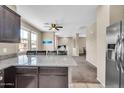 Open-concept living area featuring a kitchen island, ceiling fan, and neutral tones at 2049 N 77Th Dr, Phoenix, AZ 85035