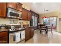 The kitchen features stainless steel appliances and dark cabinets, with a dining area nearby at 26408 N 53Rd Gln, Phoenix, AZ 85083