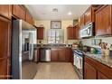 Well-lit kitchen featuring stainless steel appliances, granite countertops, and dark wood cabinetry at 26408 N 53Rd Gln, Phoenix, AZ 85083