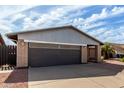 Garage of a single-Gathering home with a gray metal awning and a concrete driveway, surrounded by desert landscaping at 3106 S Extension Rd, Mesa, AZ 85210