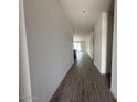 Long hallway with attractive wood flooring that flows into a spacious living area at 46922 W Coe St, Maricopa, AZ 85139