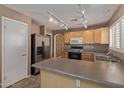 Well-lit kitchen featuring stainless steel appliances, track lighting, and a breakfast bar at 5336 W Campo Bello Dr, Glendale, AZ 85308