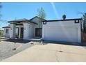 Charming single-story home with white exterior, two car garage and a well-maintained landscaped front yard at 6701 W Monterey Way, Phoenix, AZ 85033