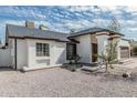 Single-story home with white stucco and brown trim, including a xeriscape yard at 6701 W Monterey Way, Phoenix, AZ 85033