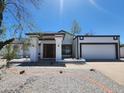 Single-story home featuring neutral paint, a gravel front yard, and attached garage at 6701 W Monterey Way, Phoenix, AZ 85033