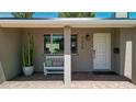 Inviting front porch with white bench seating, modern house numbers, desert landscaping and charming brick walkway at 7320 E Pierce St, Scottsdale, AZ 85257