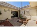 Inviting courtyard with decorative rocks, mature landscaping and exterior building with art and storage at 7615 E Tucson Rd, Scottsdale, AZ 85258