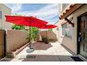 Private patio featuring red patio umbrellas, a security gate, and desert landscaping at 8061 E Glenrosa Ave, Scottsdale, AZ 85251