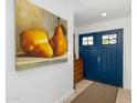 Foyer featuring a blue double door, a decorative dresser, and a painting of two pears at 8502 E Malcomb Dr, Scottsdale, AZ 85250