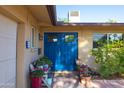 Inviting front entrance with a vibrant blue double door, potted plants, and a cozy bench at 8502 E Malcomb Dr, Scottsdale, AZ 85250