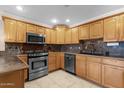 Well-lit kitchen featuring light wood cabinetry, stainless steel appliances, and tile flooring for a functional cooking space at 8644 E Roanoke Ave, Scottsdale, AZ 85257