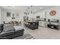 Inviting living room and kitchen with a center island, pendant lights, and stainless steel appliances at 8715 W Agora Ln, Tolleson, AZ 85353