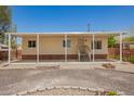 Single-story home featuring a covered porch, desert landscaping, and a gravel driveway under a clear blue sky at 9710 E Baywood Ave, Mesa, AZ 85208