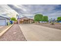 Inviting home exterior featuring a long driveway and professionally trimmed trees at 9710 N 55Th Ave, Glendale, AZ 85302