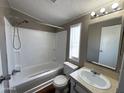 Bright bathroom featuring a shower-tub combo, sink, and toilet with a window at 1002 W Kachina Trl, Phoenix, AZ 85041