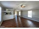 Spacious living room with hard floors, and a ceiling fan with open access to the kitchen at 1002 W Kachina Trl, Phoenix, AZ 85041