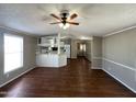 Comfortable living room with hard floors, and a ceiling fan with open access to the kitchen at 1002 W Kachina Trl, Phoenix, AZ 85041