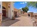 Inviting outdoor space with a brick fireplace, lush greenery, pavers, and a cozy ambiance at 1221 E Claire Dr, Phoenix, AZ 85022