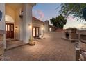 Inviting outdoor space with a brick fireplace, lush greenery, pavers, and a cozy ambiance at 1221 E Claire Dr, Phoenix, AZ 85022