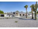 Stunning single-story home boasts desert landscaping, a gray roof, and a spacious circular driveway at 13365 N 74Th St, Scottsdale, AZ 85260