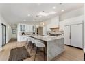Bright kitchen features an island with marble countertop, seating, and pendant lights at 13365 N 74Th St, Scottsdale, AZ 85260