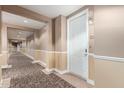 Well-lit hallway with neutral tones and patterned carpet, leading to unit 12107 at 14575 W Mountain View Blvd # 12107, Surprise, AZ 85374
