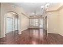 Open living room featuring hardwood floors, arched doorways, and a ceiling fan at 14575 W Mountain View Blvd # 12107, Surprise, AZ 85374