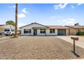 Charming home with a desert landscape front yard and ample parking provided by the long driveway and attached garage at 14635 N 37Th Pl, Phoenix, AZ 85032
